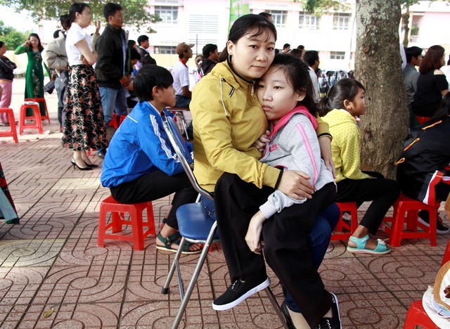 
Em Minh suốt 12 năm ròng được mẹ bế đến trường
