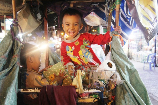 Hai anh em Hải Khang (4 tuổi) v&agrave; Thế Thịnh (18 th&aacute;ng) cười đ&ugrave;a vui vẻ trong chiếc xe đầy r&aacute;c của mẹ