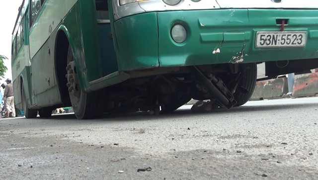Xe m&aacute;y kẹt cứng dưới gầm xe bu&yacute;t. Ảnh: Th&aacute;i Linh.