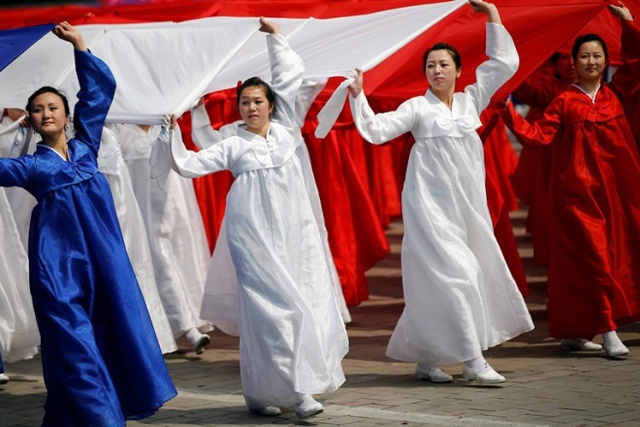 
Người dân cầm những tấm vải màu cờ Triều Tiên trình diễn. Ảnh: Reuters
