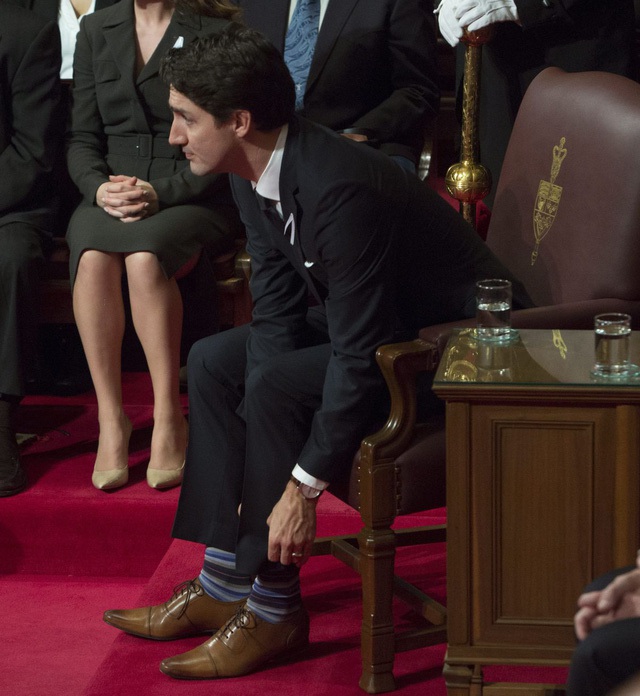 
Ông Trudeau chỉnh lại tất trước khi có bài phát biểu tại thượng viện ở thủ đô Ottawa, Canada tháng 12/2015.
