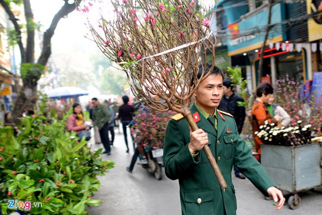 Tận dụng khoảng thời gian nghỉ trưa ít ỏi, thiếu uý Trần Trung Hiếu xuống phố hoa, sắm một cành đào, mang không khí xuân về đơn vị.