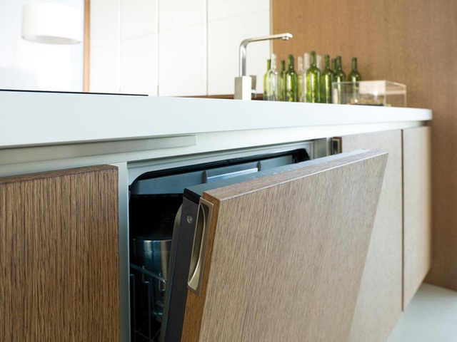 Không hề lộ ra các tay nắm ở tủ bếp, thay vào đó là thiết kế dạng bấm giúp không gian trông hiện đại hơn. Bếp cũng được thiết kế gần khu vực