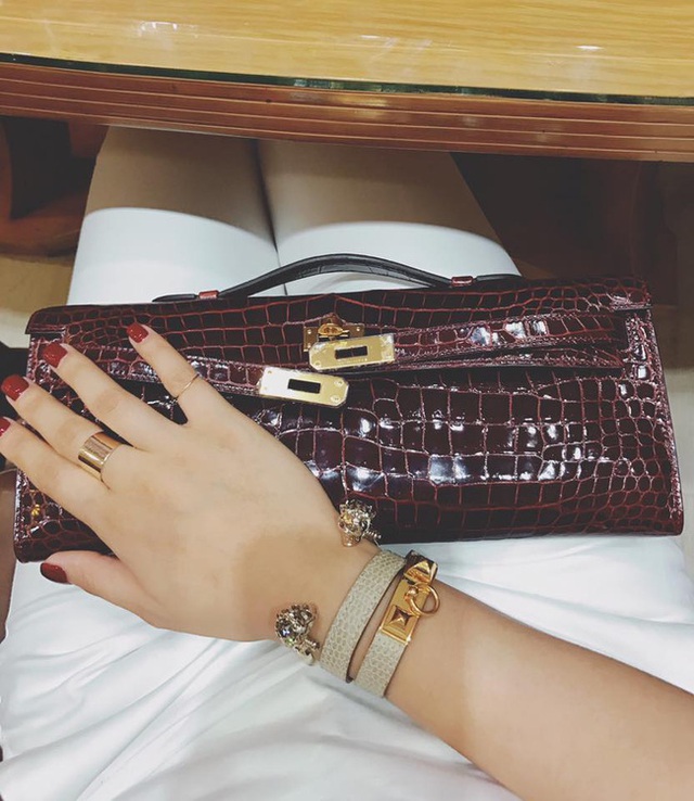 
Miu Lê rất chuộng da cá sấu. Một mẫu clutch dài khác là Hermes Shiny Porosus Crocodile Kelly, chất liệu da cá sấu, có giá cũng lên đến khoảng hơn 800 triệu đồng!!! Chưa hết, Miu Lê còn kết hợp rất đủ bộ với 2 chiếc vòng, một chiếc là Hermes Rivale Double Tour có giá khoảng 16-18 triệu đồng, còn một chiếc là vòng Alexander McQueen có giá khoảng 7 triệu đồng.
