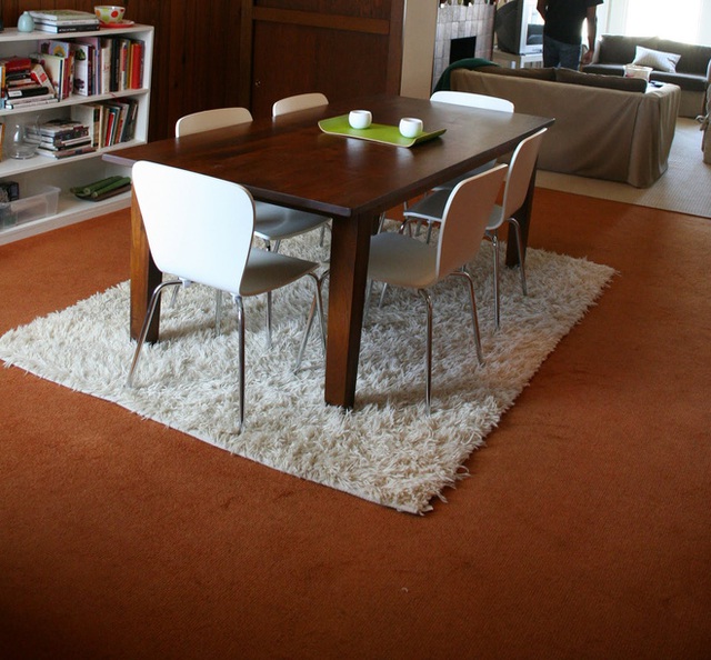 Một bàn gỗ mộc mạc kết hợp với ghế trắng hiện đại tạo ra một tình huống mà hai loại trang trí gần như mâu thuẫn nhau. Bạn cần phải có tấm thảm lót xù trắng để làm nổi bật.