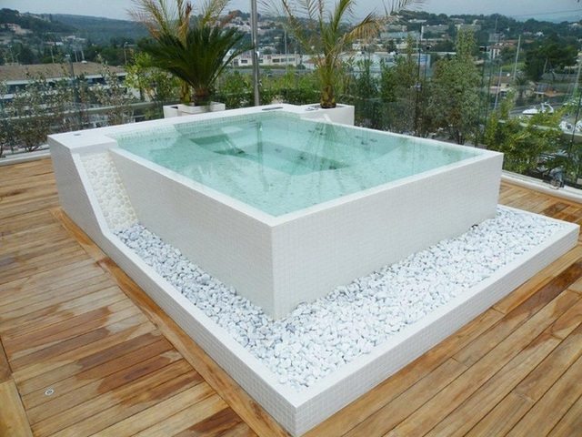 13. Một bể sục h&igrave;nh vu&ocirc;ng được trang tr&iacute; bằng những vi&ecirc;n sỏi trắng tr&ecirc;n s&agrave;n gỗ tr&ocirc;ng rất tự nhi&ecirc;n v&agrave; tinh tế.