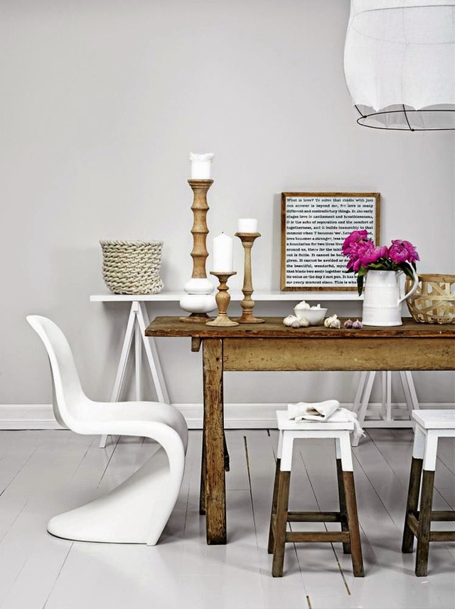 Những chiếc ghế đẩu hai màu: trắng và gỗ, chiếc bàn ăn bằng gỗ nổi bật trên sàn gỗ màu trắng cũng như khi kết hợp với chiếc ghế kiểu lạ cũng màu trắng.