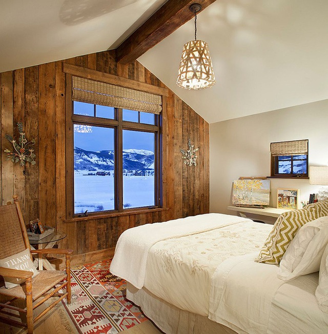 Phòng ngủ mang phong cách rustic rộng rãi và thanh bình với tường gỗ tái chế bao ô cửa sổ nhìn ra phong cảnh bên ngoài.