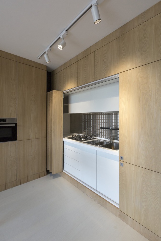 Ngay cả khu bếp nấu cũng được ẩn gọn gàng sau những cánh cửa gỗ, vừa gọn gàng, vừa đủ chức năng. Một cách thiết kế rất thông minh cho nhà chật.