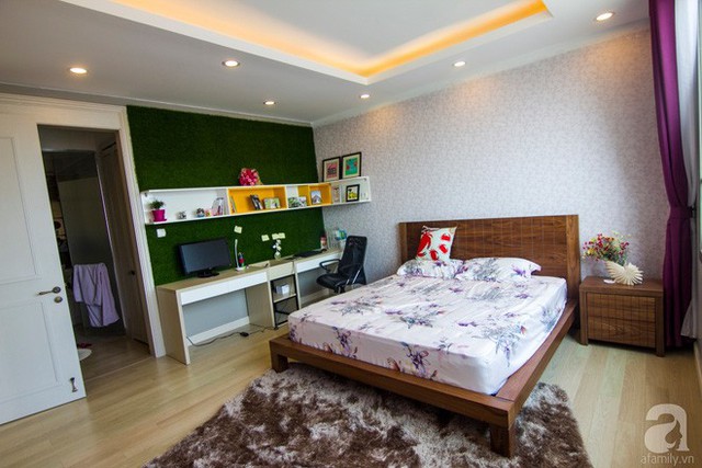 Chiếc giường gỗ nhỏ xinh được kê ở giữa, phần bàn và kệ làm việc được bố trí sát tường với màu xanh cỏ cây ốp tường làm màu nhấn.