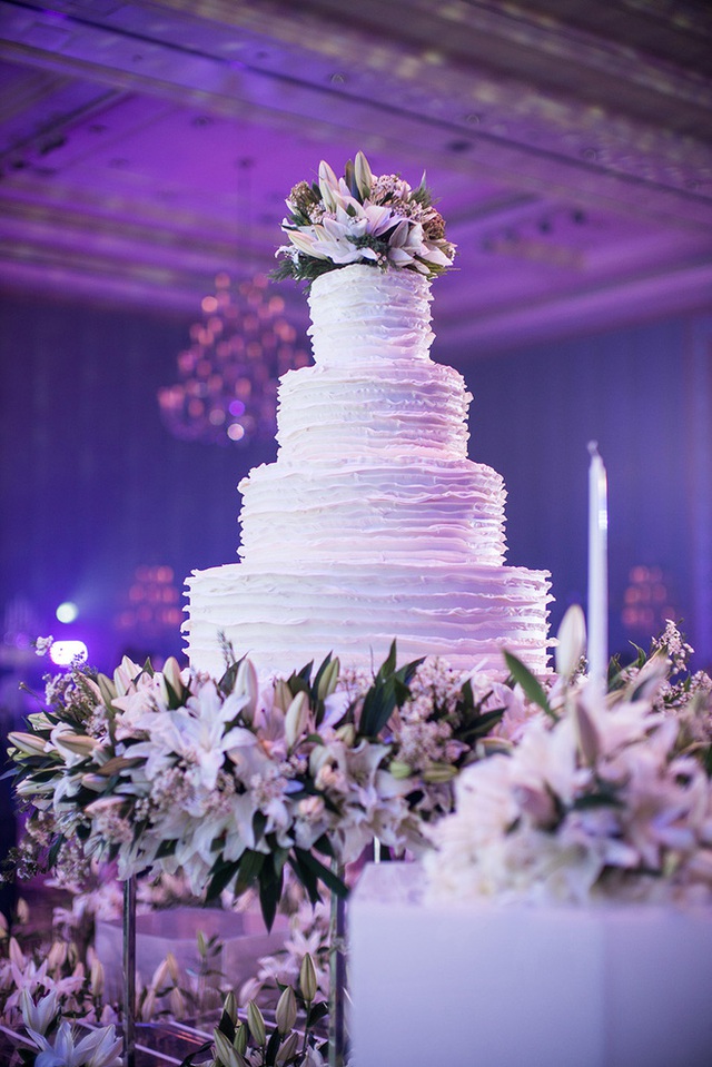 
Chiếc bánh cưới khổng lồ được trang trí bằng màu kem trang nhã.
