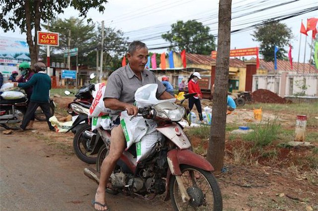 Trẻ nhỏ, người gi&agrave; c&ugrave;ng x&uacute;c c&aacute;t v&agrave;o bao, đưa về chằng m&aacute;i nh&agrave;.