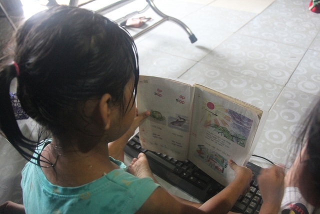 
Không có tiền đi học, 2 bé gái song sinh chỉ biết ở nhà lấy tập vở ra đợi bố về chỉ cho học chữ
