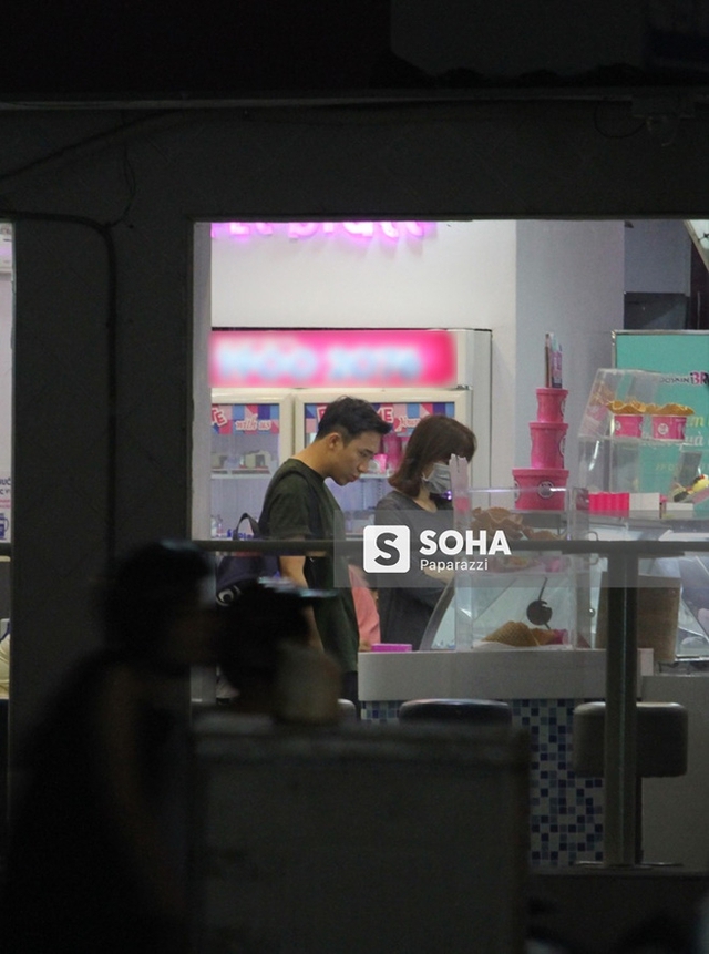 Trấn Thành và Hari Won dừng lại trước một cửa hàng bán đồ ngọt.