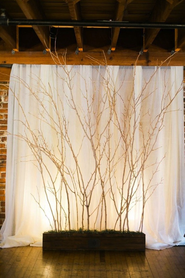 Kiếm những nhánh cây khô để trang trí cho background đám cưới của bạn là một ý tưởng độc đáo khác. Bạn có thể gắn thêm hoa và lá để tạo cảm giác như một cái cây thật, hay treo bóng bay và những tấm thiệp lời chúc lên đây.