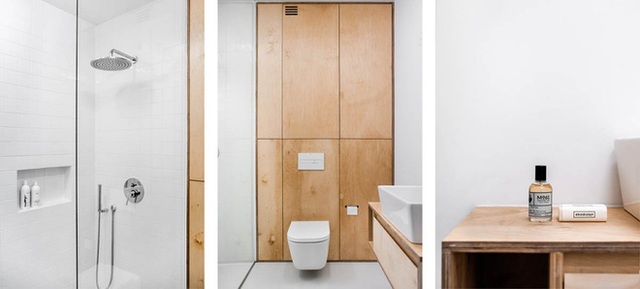 Góc vệ sinh được thiết kế đơn giản với những vật dụng cần thiết. Phòng tắm đứng và khu vực vệ sinh được thiết kế tách biệt. Sự kết hợp màu trắng của gạch, của ánh sáng với hệ thống tủ âm tường bằng gỗ mang đến sự cân đối cho tổng thể không gian.