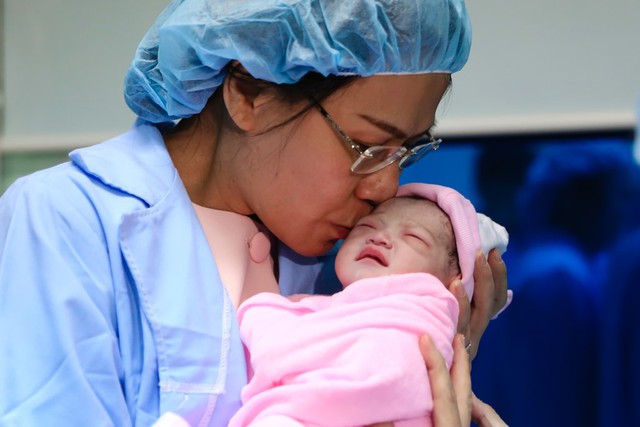 B&agrave; Thu trao nụ h&ocirc;n cho b&eacute; g&aacute;i con chị Trinh.