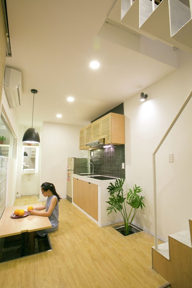 Tầng trệt kết hợp phòng gia đình, phòng ăn tối và nhà bếp. Để làm cho các chức năng này hoạt động linh hoạt và tối đa hóa không gian sử dụng, sàn được nâng lên để lại không gian dưới được phục vụ như băng ghế ăn tối cạnh bàn ăn.