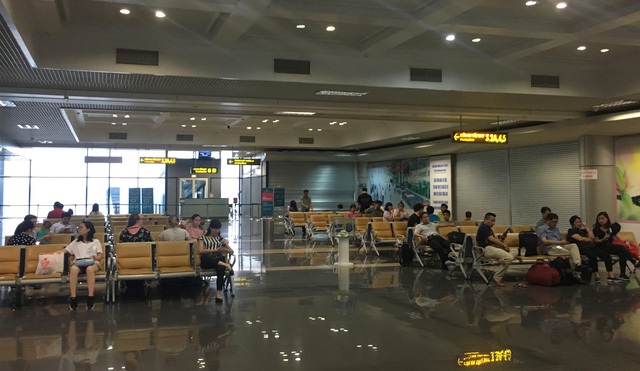 
Bên trong khu vực cách ly, hành khách ngồi chờ chuyến bay
