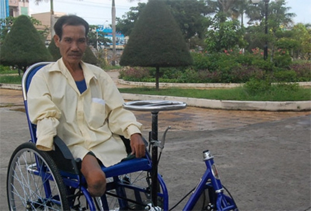 &Ocirc;ng Nguyễn Văn Tr&iacute; v&agrave; chiếc xe lăn được Đại tướng Phạm Văn Tr&agrave; tặng c&aacute;ch đ&acirc;y 6 năm. (Ảnh: B&aacute;o QĐND)