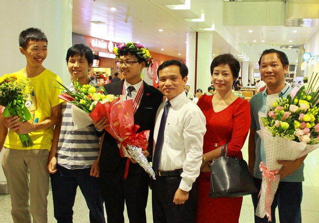 
Đinh Anh Dũng trong vòng tay đón chào của thầy cô, bạn bè tại sân bay Nội Bài tối 24/7.
