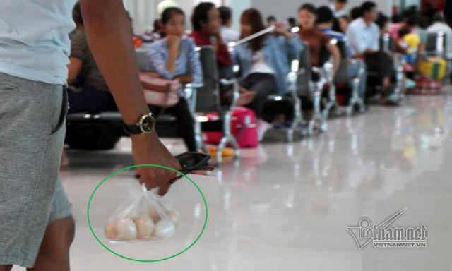 Một h&agrave;nh kh&aacute;ch x&aacute;ch trứng g&agrave; l&ecirc;n m&aacute;y bay. Ảnh: Quốc Huy