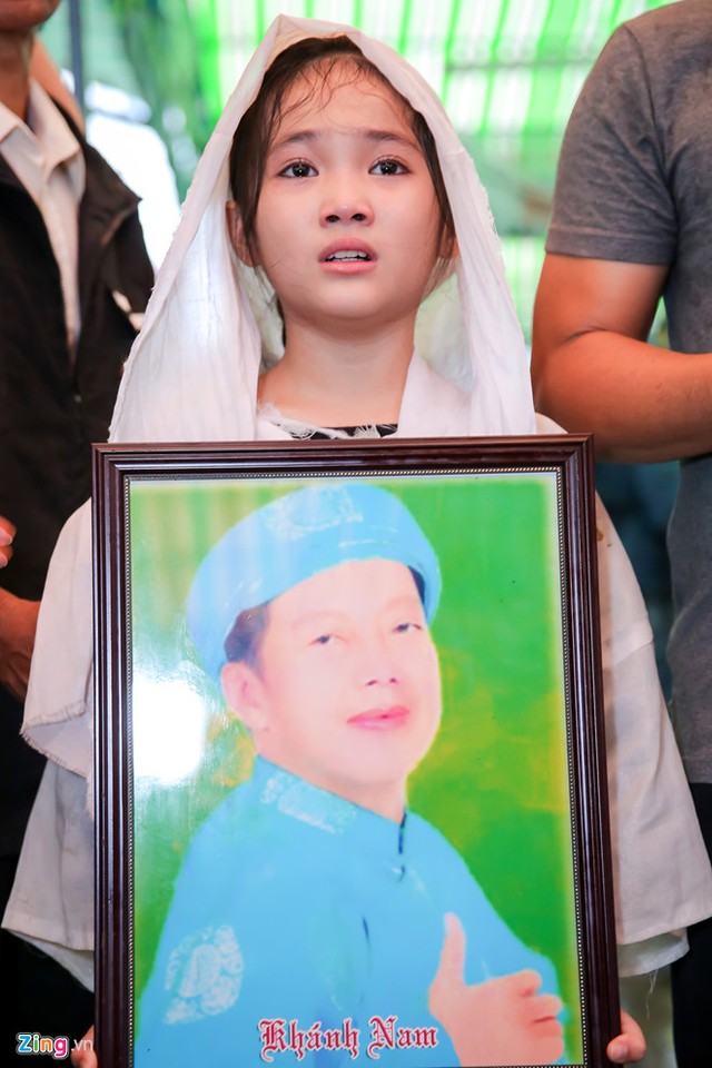 Bé Khánh Nhi - con nuôi Khánh Nam thẫn thờ đưa tiễn cha. Những ngày qua, cô bé 11 tuổi luôn túc trực bên linh cữu cha nuôi. Trước đó, cô được nghệ sĩ Khánh Nam hỗ trợ diễn xuất khi tham gia Sao nối ngôi.
