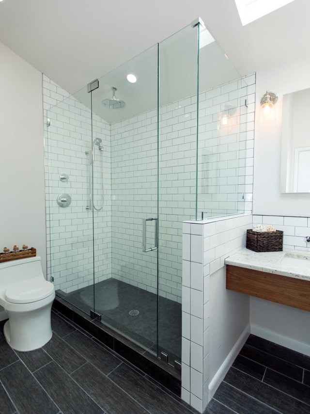 Phòng tắm mới được thay đổi toàn bộ với sàn nhà lát gạch màu đen, phòng tắm được lắp kính tạo không gian mở thay vì dùng rèm treo và gạch ốp tường màu trắng tạo cảm giác vừa hiện đại vừa sạch sẽ. 