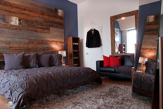 Phòng ngủ tinh tế của một căn hộ penthouse với bức tường sử dụng 3 loại gỗ tái chế khác nhau.