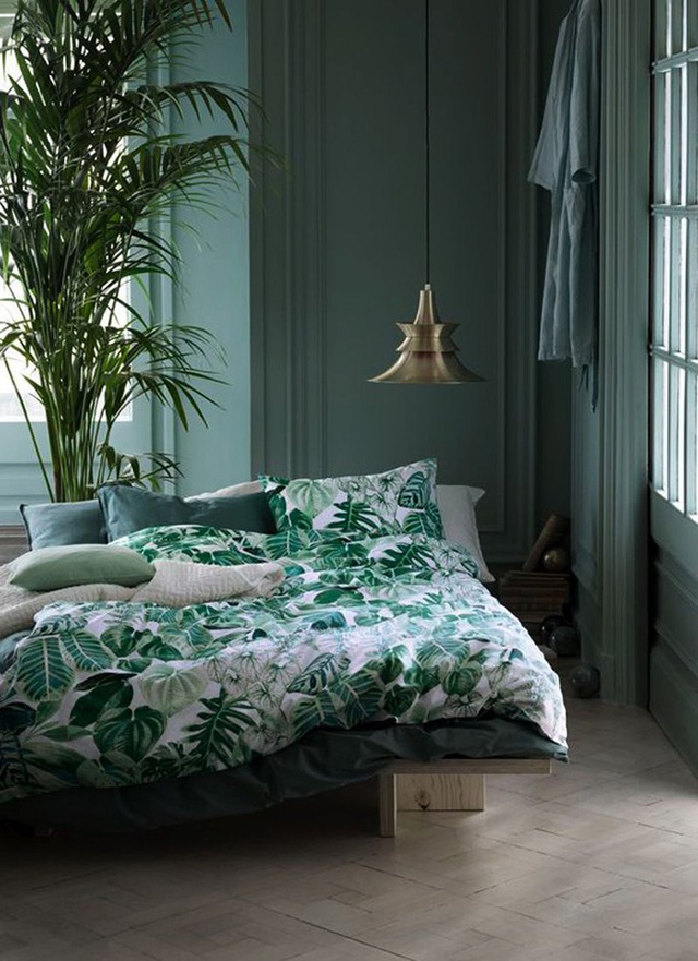 Một chậu cây lớn và vỏ ga họa tiết lá cây đã mang đến cảm giác mát mẻ, thư giãn cho phòng ngủ.