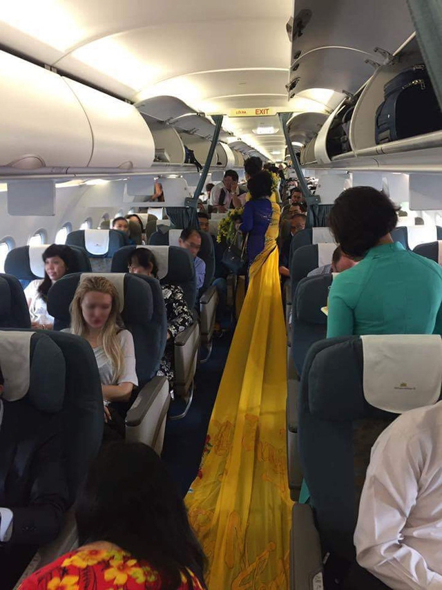 
Nhiều hành khách tò mò về tà áo dài hàng chục mét của bà Thúy Nga. Ảnh: Facebook
