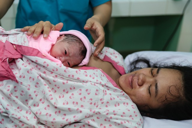 Em b&eacute; được cho nằm l&ecirc;n bụng để tiếp x&uacute;c với mẹ sau khi sinh.