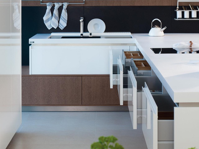 Tường bếp ốp đá màu xanh đen sạch sẽ, kết hợp với nội thất màu trắng tương phản tạo nên sự tinh tế giản đơn.