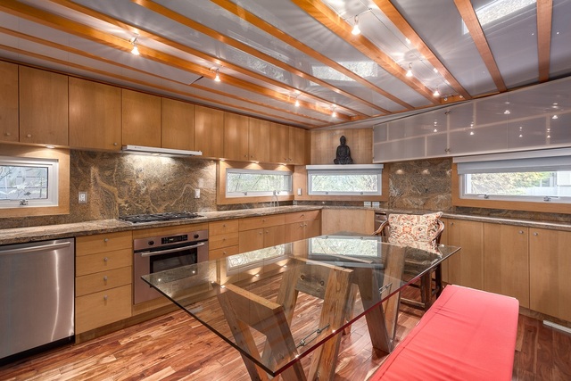 Phòng bếp được thiết kế bằng vật liệu thủy tinh một cách tối đa. Từ bàn thủy tinh, cửa sổ, trần nhà, thành bếp, tủ.