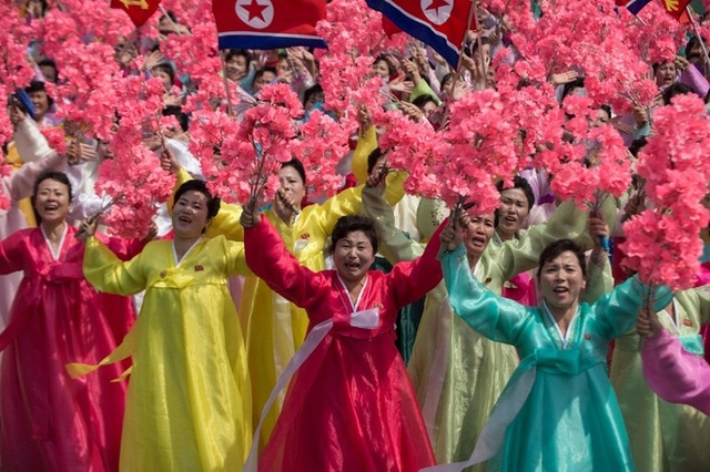 
Phụ nữ Triều Tiên trong trang phục truyền thống vẫy hoa. Ảnh: AFP
