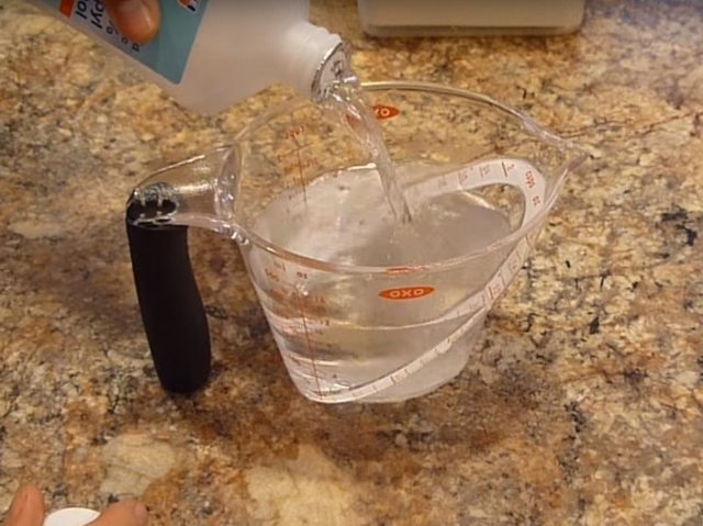 Hòa tan giấm với nước trắng và isopropy alcohol với tỷ lệ như nhau vào một chiếc cốc.
