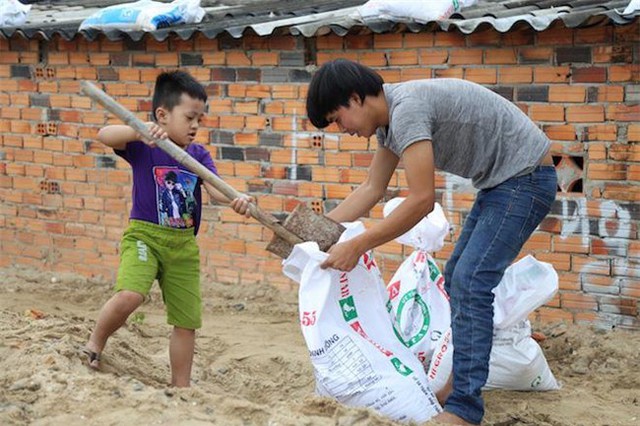 Kh&ocirc;ng kh&iacute; ph&ograve;ng chống b&atilde;o đang diễn ra kh&aacute; khẩn trương, trẻ em cũng phụ gi&uacute;p gia đ&igrave;nh x&uacute;c c&aacute;t v&agrave;o bao.
