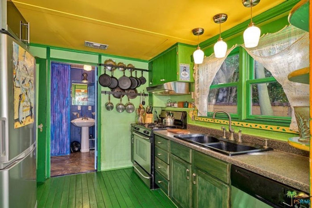 Phòng bếp sơn màu xanh lá với trần màu vàng.