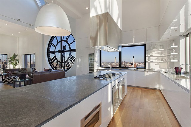 Gian nhà bếp đơn giản, hiện đại được thiết kế nằm kế bên không gian phòng khách. Các cửa sổ bằng kính trong suốt giúp chủ nhân căn hộ vừa làm bếp vừa có thể ngắm khung cảnh bên ngoài.