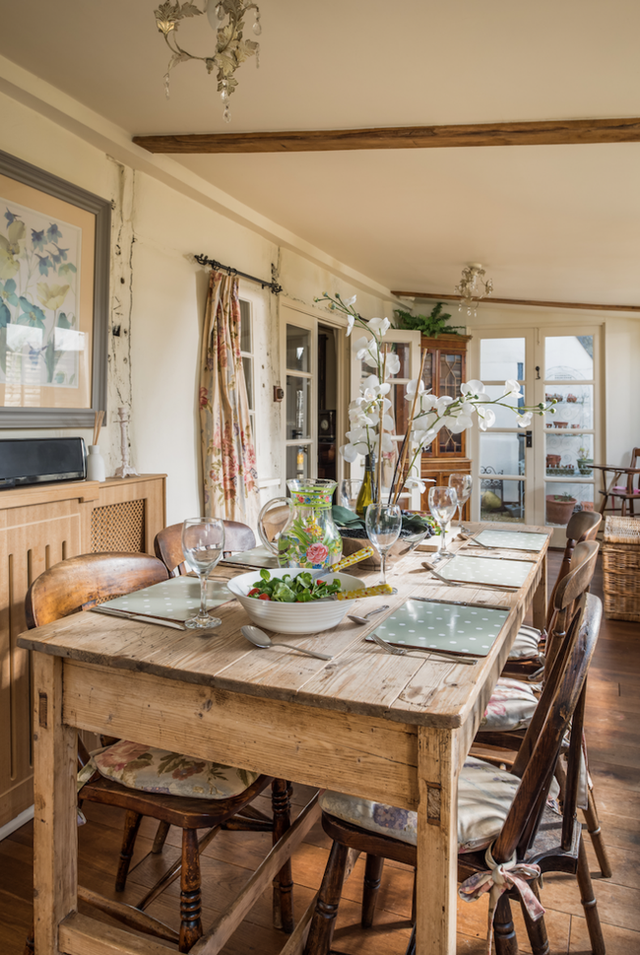 Phòng ăn đơn giản với chiếc bàn gỗ chạy dài được ghép từ những thanh gỗ và những chiếc ghế gỗ cùng nệm buộc để ngồi.