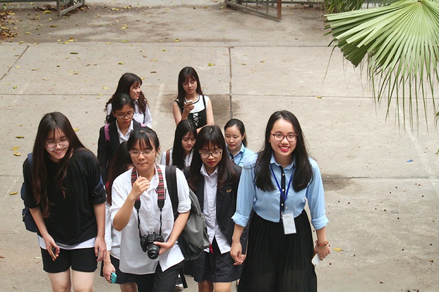 Nữ sinh Ngoại giáo (áo xanh) dẫn các em học sinh đi tour tham quan trường học