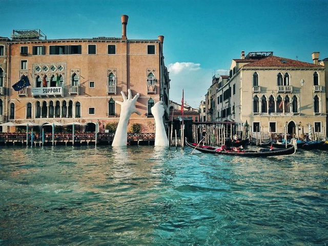 
Đôi tay trồi lên từ sóng nước rập rờn của dòng sông Venice thơ mộng.
