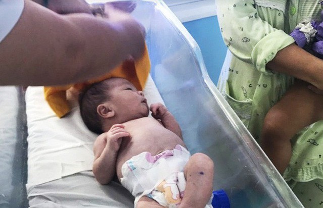 Đứa b&eacute; được bận quần &aacute;o mới để về nh&agrave; c&ugrave;ng mẹ.