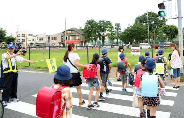 Nhóm đảm bảo an toàn cho học sinh do hội phụ huynh cùng ban tự quản thành phố lập ra giúp các bé đi bộ tới trường.