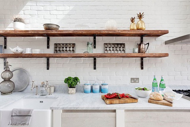 Nhà bếp toàn màu trắng từ tường với các kệ mỏng và dài đến từ gỗ.