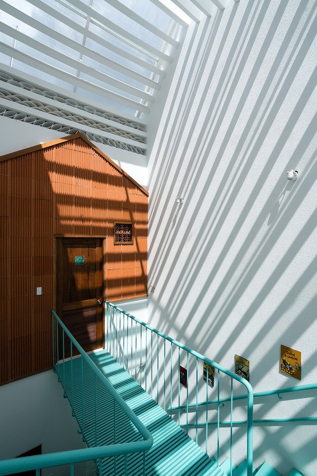 Hệ cầu thang bằng thép màu sắc và mặt tiền độc đáo tạo sự riêng tư cho các phòng.