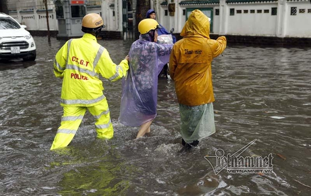 Lực lượng CSGT vừa điều tiết giao th&ocirc;ng, vừa gi&uacute;p đỡ người d&acirc;n trong mưa ngập