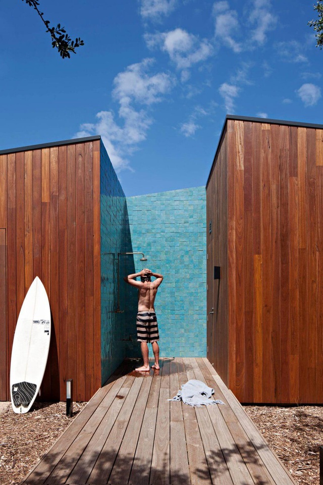 Một khu vực tắm tiên được bố trí ngay sát bên ngoài của ngôi nhà với các tấm gỗ được dựng lên bao quanh để che chắn. Chủ nhân đã cho sơn màu gỗ thành xanh dương để trông nó như một bãi biển thu nhỏ vậy.