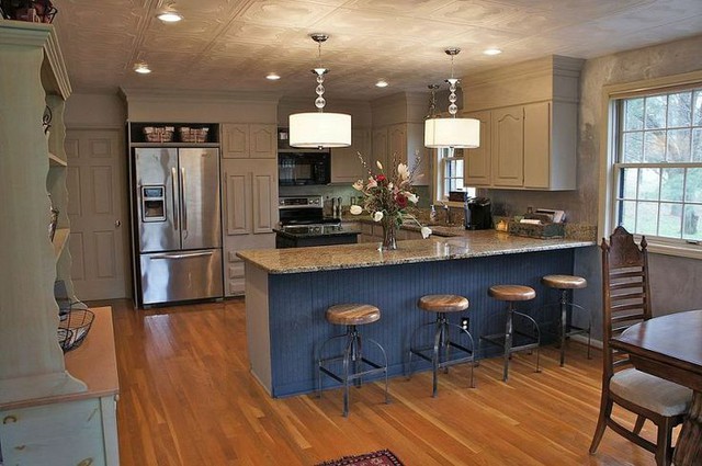 Những chiếc tủ bếp được sơn màu nâu và màu kem tạo nên phong cách rustic. Chiếc đèn treo ở phía đảo bếp cũng mang lại cảm giác hiện đại và tươi sáng hơn cho phòng bếp này.