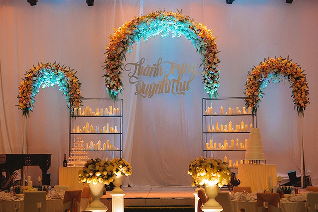 
Trong khu vực đãi tiệc, wedding planner sử&nbsp;dụng hàng nghìn ngọn nến từ cổng vào đến đường dẫn lên sân khấu và trên sân khấu chính. Ba vòm hoa tươi kết chùm có tone màu hồng, kem ngọt ngào.
